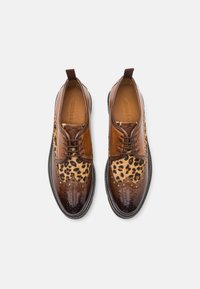 Brown leather shoes featuring a leopard print leather insert, brogue detailing, round toe, and lace-up design with a sturdy sole.