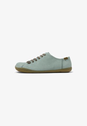 Light green suede shoe with a rounded toe, brown laces, and a flexible rubber sole. Notable stitching accents along the sides.