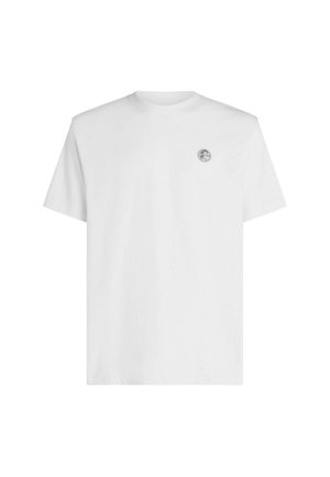 Valkoinen puuvillainen T-paita pyöreällä kaula-aukolla, lyhyillä hihoilla ja pienellä logopläkki vasemmassa rinnassa. Sileä tekstuuri ja klassinen istuvuus.