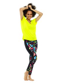 Neon yellow loose top paired with black leggings featuring a colorful geometric pattern; smooth texture; casual athletic wear.