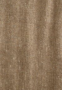 Tissu en laine à chevrons marron et beige avec un tissage texturé et un motif de fines rayures verticales.