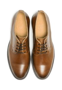 Chaussures habillées en cuir marron à finition lisse, avec un bout arrondi, un laçage à six œillets et des détails de couture subtils sur la tige.
