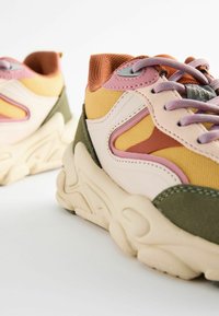 Mångfärgade sneakers med ett överdel av mesh och syntetmaterial i gult, rosa och grönt. Tjock mellansula med strukturerad design och mjuka skosnören.