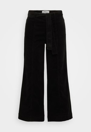 Fekete kordbársony, bő szárú nadrág, derékban megkötős övvel, textúrázott felülettel és struktúrált formával, alkalmas hétköznapi viseletre.