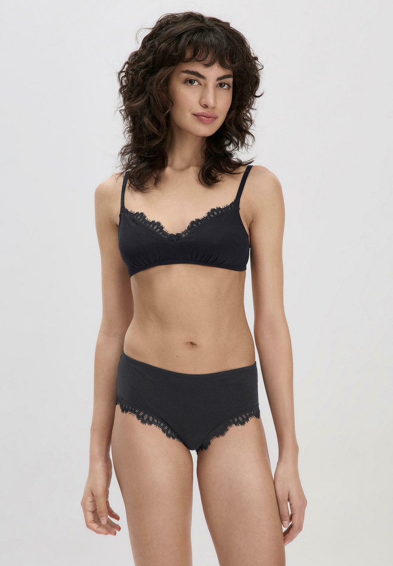 Zwarte set van een bh en slip met kantafwerking. De stof is glad met een zachte textuur en heeft delicate kantaccenten langs de randen.