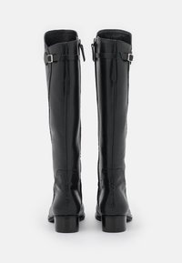 Schwarze Leder-Stiefel bis zum Knie mit glatter Oberfläche, strukturierten Einsätzen und kleinen Schnallen-Akzenten an der Oberseite. Blockabsätze runden das Design ab.