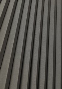 Tessuto plissato di colore grigio scuro, con strette pieghe verticali finemente distanziate, dalla texture liscia e un sottile lucido.