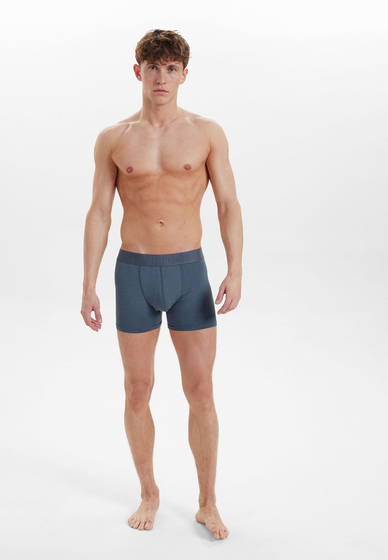 Dark blue boxer briefs with a textured waistband display a snug fit and smooth fabric, suitable for everyday wear.