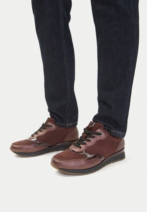 Brązowe buty sportowe wykonane z mieszanki skóry teksturowanej i zamszu. Posiadają czarne sznurowadła, błyszczące akcenty oraz amortyzowaną podeszwę.