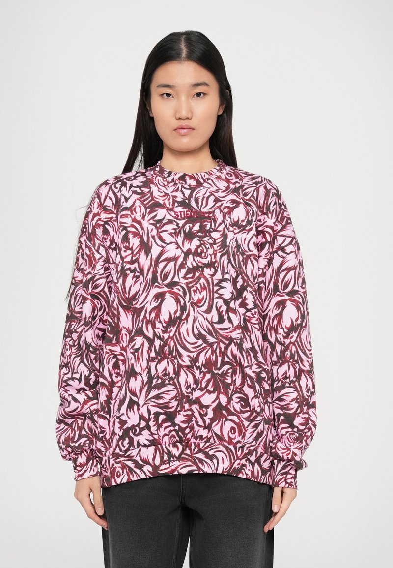 Suéter de manga larga en rosa con un patrón floral, con un escote redondo y un corte relajado. El material parece suave y texturizado.