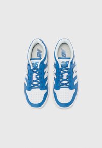 Blauwe en witte sport schoenen met een soepele leren bovenkant, geperforeerde neus, witte veters en een prominent 'N' logo aan de zijkanten.