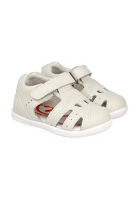 Sandalias ligeras de piel blanca con detalles troquelados, correa ajustable y acentos rojos en la plantilla. Presenta una suela blanca flexible.