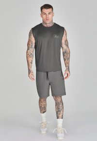 Donkergrijs mouwloos topje en bijpassende short, gemaakt van lichtgewicht stof met een gladde textuur. Bevat een logo en details met trekkoord.