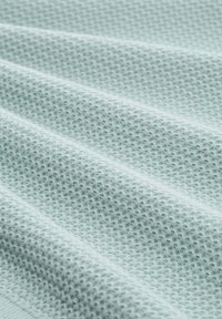 Šviesiai mėlynas tekstūruotas audinys su korio raštu, su keliais raukšlėmis, suteikiančiomis gylio ir švelnios apšvietimo efektą. Puikiai tinka drabužiams ar apmušalams.