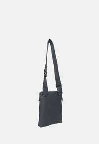 Borsa a tracolla grigia realizzata in materiale testurizzato, con una singola tracolla regolabile e una chiusura con zip sulla parte superiore. Design piatto.