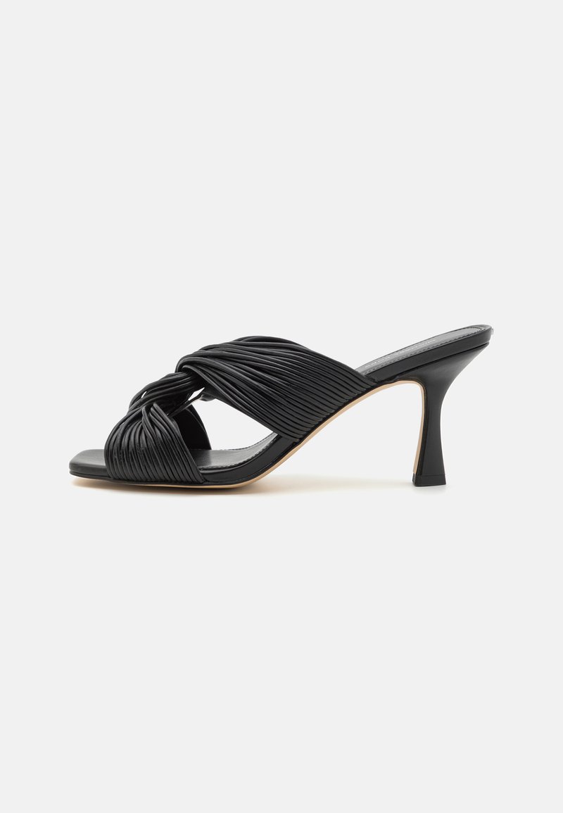 Sandale à talons hauts noire avec un design plissé torsadé, orteils ouverts et un talon stiletto effilé. Texture en cuir lisse.