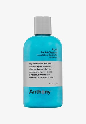 Bouteille en plastique bleu avec un capuchon gris. Le texte à l'avant indique "Nettoyant Facial aux Algues". Le dos fournit des informations sur les ingrédients et l'utilisation. 237 ml.