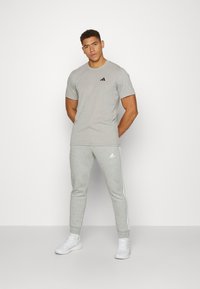 adidas Sportswear ESSENTIALS TAPERED CUFF 3-STRIPES  - Treniņtērpa apakšdaļas - medium grey heather