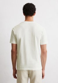 Light cream short-sleeve t-shirt with a round neck, made of soft fabric, featuring a clean, simple design, and a relaxed fit.