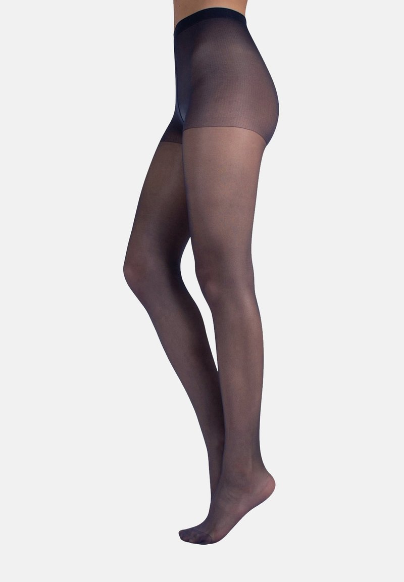 Nahaufnahme von Beinen, die transparente schwarze Strumpfhosen mit einem undurchsichtigen hochgeschnittenen Bereich tragen, auf Zehenspitzen vor einem einfarbigen Hintergrund stehend.