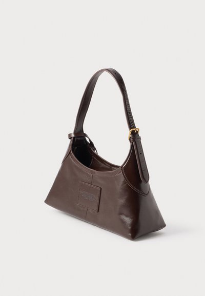 Sac à main en cuir marron foncé avec une sangle incurvée unique et une boucle dorée sur un fond clair uni.