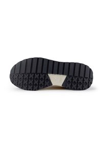 Semelle de chaussure en caoutchouc noir avec des crêtes texturées et des motifs triangulaires, présentant une section blanche avec un logo au centre.
