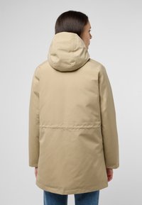 Veste à capuche beige avec une texture lisse, une taille cintrée, des manches longues et une coupe droite. La vue arrière met en valeur un design minimaliste.