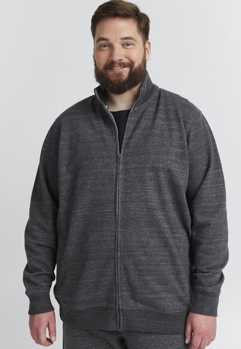 Mörkgrå zip-up sweatshirt med hög krage, ribbade ärmslut och nederkant, samt ett mjukt, strukturerat tyg. Designen är enkel och avslappnad.