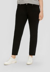 Zwarte slim-fit broeken van een katoenmix. Bevat zij- en achterzakken, riemlussen en een sluiting met een knop aan de voorkant. Gecombineerd met witte sneakers.
