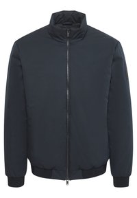 Tamsiai mėlynas paminkštintas bombonešio tipo švarkas su aukštu apykakle, visiškai užtraukiamu užtrauktuku, gurnuota rankovėmis ir apatine dalimi, pasižymintis matinio paviršiaus ir minimaliai ženklinimo elementais.