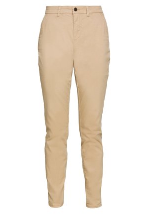 Μπεζ βαμβακερά chinos με στενή εφαρμογή, διαθέτουν κλείσιμο μπροστά με κουμπί, πλαινές τσέπες και ελάχιστες ραφές. Ισορροπημένη υφή.