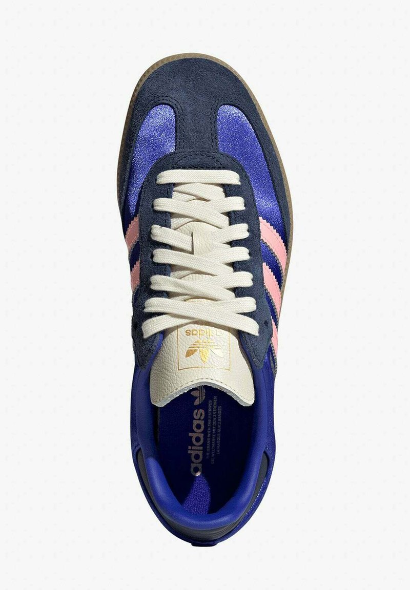Navy and purple sneaker with suede upper, pink stripes, and white laces. Features a textured leather tongue and a classic rubber sole.