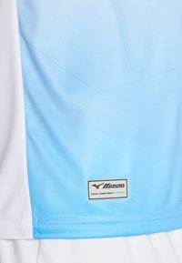 Maglietta atletica azzurro chiaro e bianca realizzata in tessuto traspirante, con un'etichetta rettangolare del logo Mizuno e cuciture rinforzate per la durata.