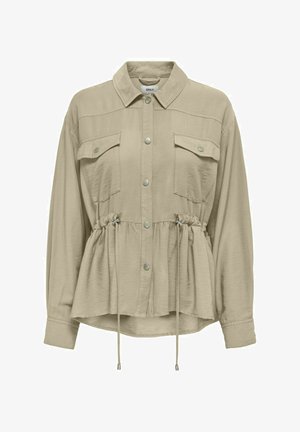 Chemise crème à manches longues avec un col, poches poitrine, taille élastiquée et fermeture à boutons sur le devant. Tissu doux et léger.