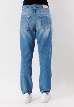 Jeans in denim blu chiaro con vestibilità rilassata, dotati di due tasche posteriori e un'etichetta del marchio sulla vita. Il tessuto ha un aspetto sbiadito.