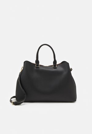 Sac à main en cuir noir avec deux poignées supérieures, une bandoulière amovible et des accessoires couleur or sur un fond blanc uni.