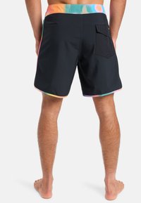 Schwarze Badehosen mit einem mehrfarbigen Batikbund, ausgestattet mit einer Tasche auf der Rückseite, glattem Stoff und einem Schnitt bis zur Mitte des Oberschenkels.