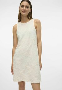 Ärmlös knälång klänning i ljus grädde med texturerade blommönster. Tillverkad av mjukt tyg med en avslappnad passform och rund halsringning.