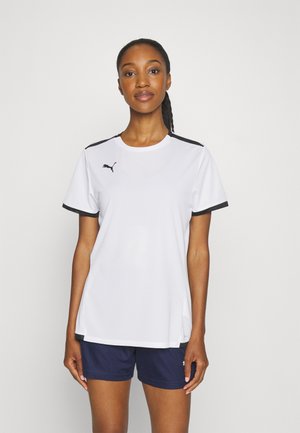 Weißes Sport-T-Shirt mit schwarzem Saum und kleinem Logo, kombiniert mit blauen Shorts. Es hat einen Rundhalsausschnitt und kurze Ärmel.