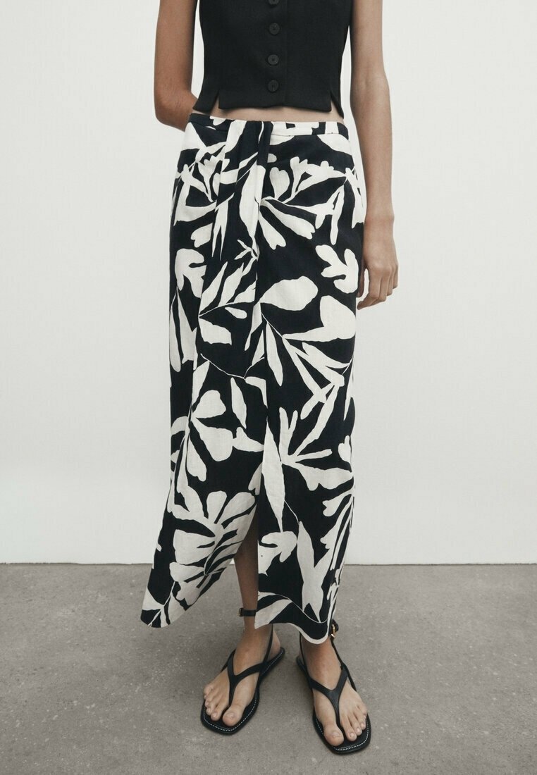Zwart-wit bloemenprint rok met een wikkelontwerp, gemaakt van lichtgewicht stof, met een zijsplit en gecombineerd met zwarte sandalen.