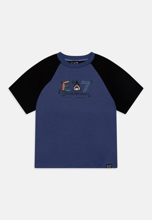 Camiseta raglán de manga corta azul marino y negra con el logo colorido "EA7 Emporio Armani" que incluye una tabla de surf, un tiburón y un diseño a rayas.