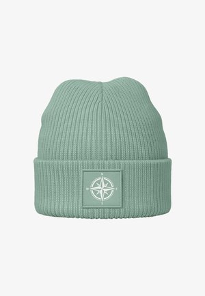 Hellgrüne Strickmütze mit geripptem Muster und einem quadratischen Patch mit einem weißen Kompassdesign.