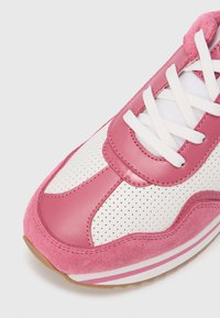 Ροζ και λευκό αθλητικό παπούτσι με διάτρητες λεπτομέρειες, λείο δέρμα,  σουέντ διακοσμήσεις και λευκά κορδόνια με υφή σε καουτσούκ σόλα.