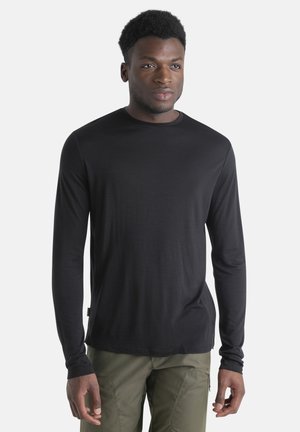 Zwart langemouwshirt met een ronde hals. Gemaakt van een soepele stof. De pasvorm is casual, met aansluitende mouwen en een rechte zoom.