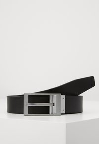 Zwarte leren riem met een gladde textuur, voorzien van een rechthoekige zilveren metalen gesp en een eenvoudig, strak ontwerp.