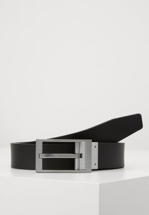 Cintura in pelle nera con texture liscia, dotata di una fibbia rettangolare in metallo argento e un design semplice ed elegante.