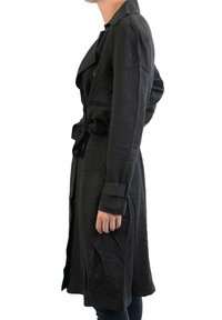Manteau noir en trench avec une ceinture à nouer, doté d'un col à revers, de manches longues et de poches latérales, fabriqué dans un tissu lisse et léger.