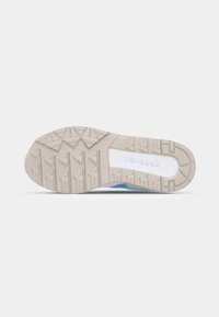 Shoe sole made of rubber with a beige color, featuring a textured pattern for grip. The side has a cutout with branding in white.
