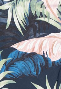 Tecido floral com grandes folhas verdes, detalhes em rosa pálido e tons de azul sobre um fundo escuro; textura suave com padrões detalhados.