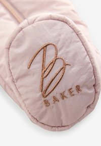 Hellrosa gefüttertes Accessoire mit einem runden Patch, auf dem die braun gestickten Initialen "B" und das Wort "BAKER" abgebildet sind. Glatte Textur.
